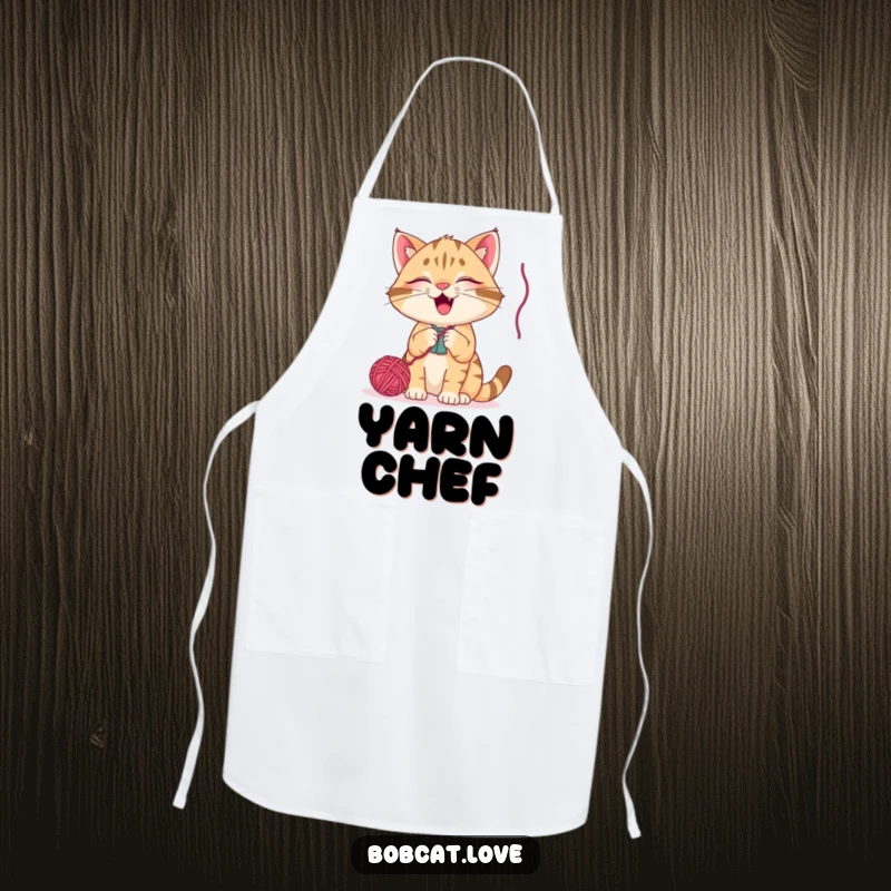 Funny bobcat apron, a happy cat batting at a dangling yarn ball, a humorous kitchen accessory for playful chefs and cat enthusiasts.