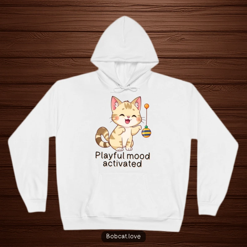 Funny bobcat with a vigorously wagging tail, playfully swatting a dangling toy, featured on a comfortable hoodie.