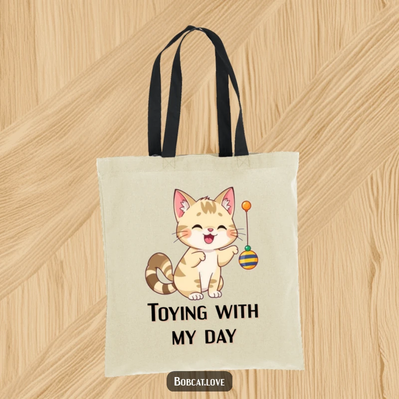 Funny bobcat with a happy, wagging tail, captured mid-bat at a dangling toy, printed on a durable tote bag.